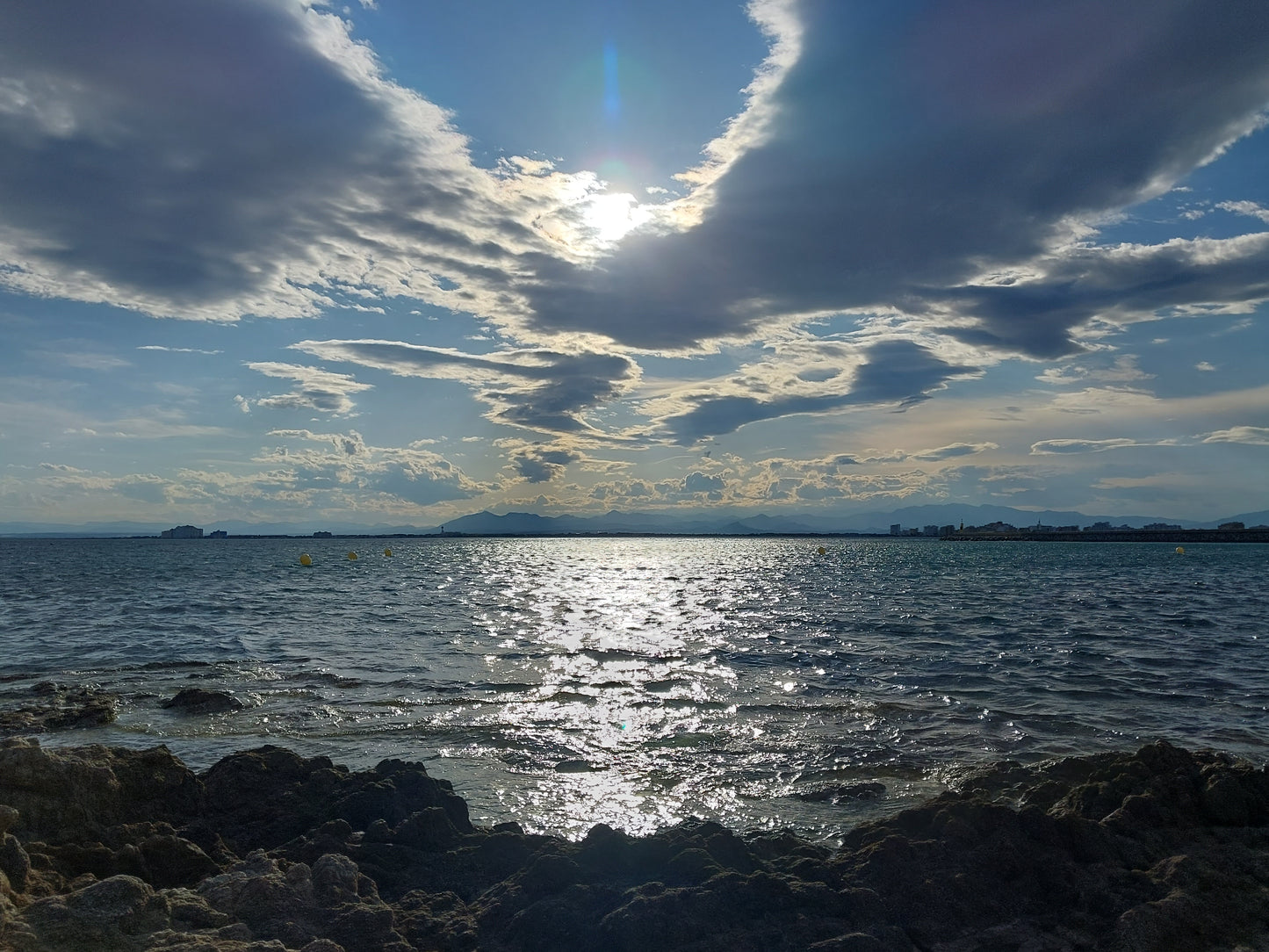 Maravilloso paisaje marino con cielo con nubes y destellos solares encima del mar que te transportan entre el cielo y la tierra y cerca de él. Varios tamaños