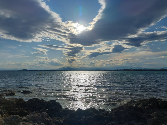 Maravilloso paisaje marino con cielo con nubes y destellos solares encima del mar que te transportan entre el cielo y la tierra y cerca de él. Varios tamaños